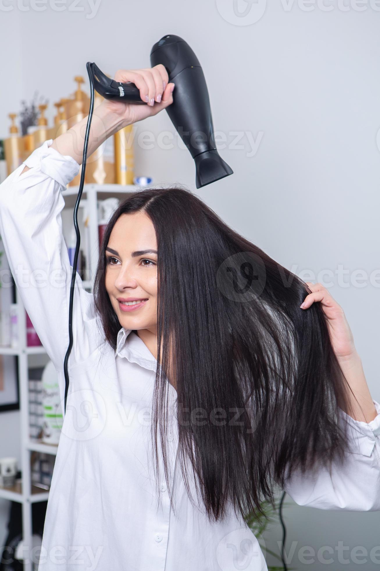 mulher jovem e bonita usando secador de cabelo no salão de cabeleireiro.  close-up do cabelo da mulher no salão de beleza, conceito de penteado  19576795 Foto de stock no Vecteezy